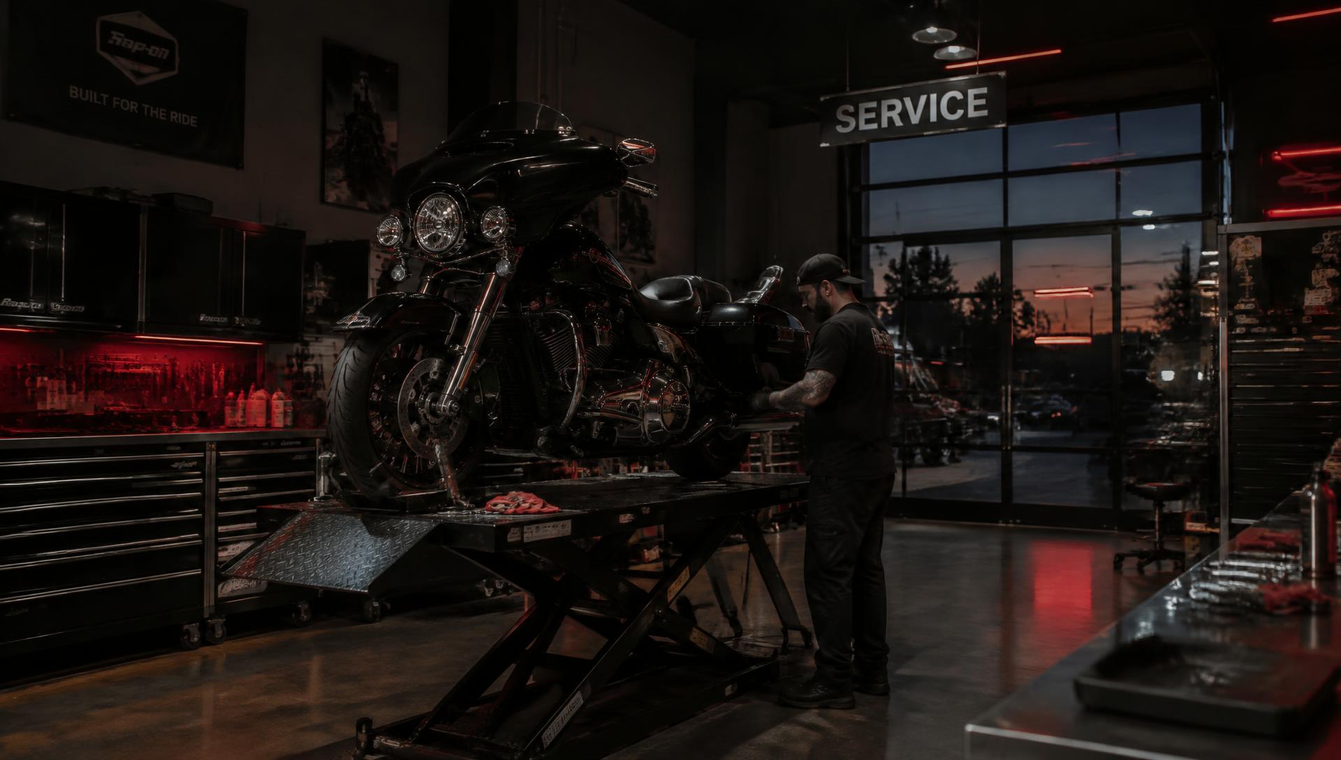 Technician servicing a touring motorcycle on a lift inside the GLM Power Sports shop